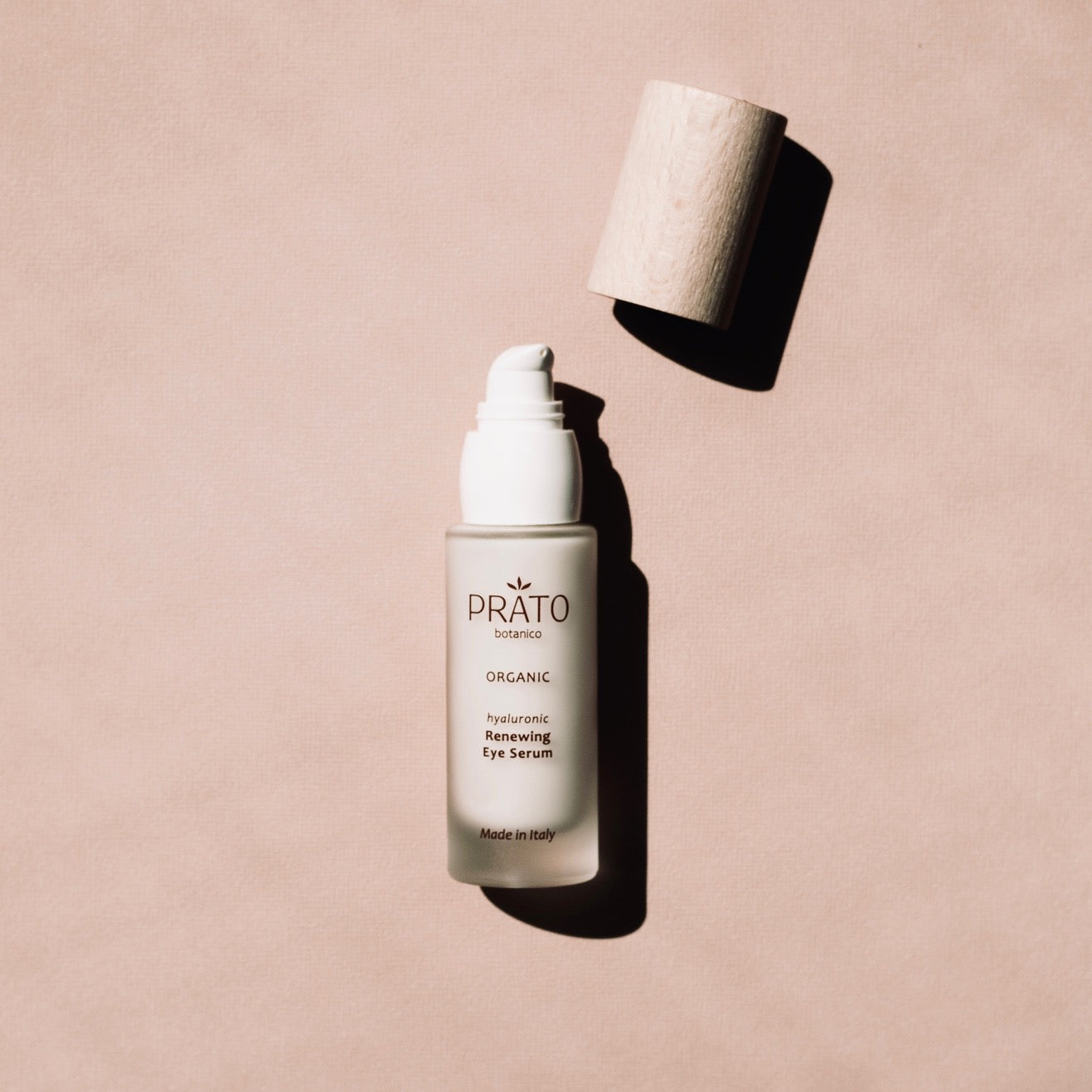 Prato Botanico Renewing Eye Serum with sustainable beechwood lid on pink background