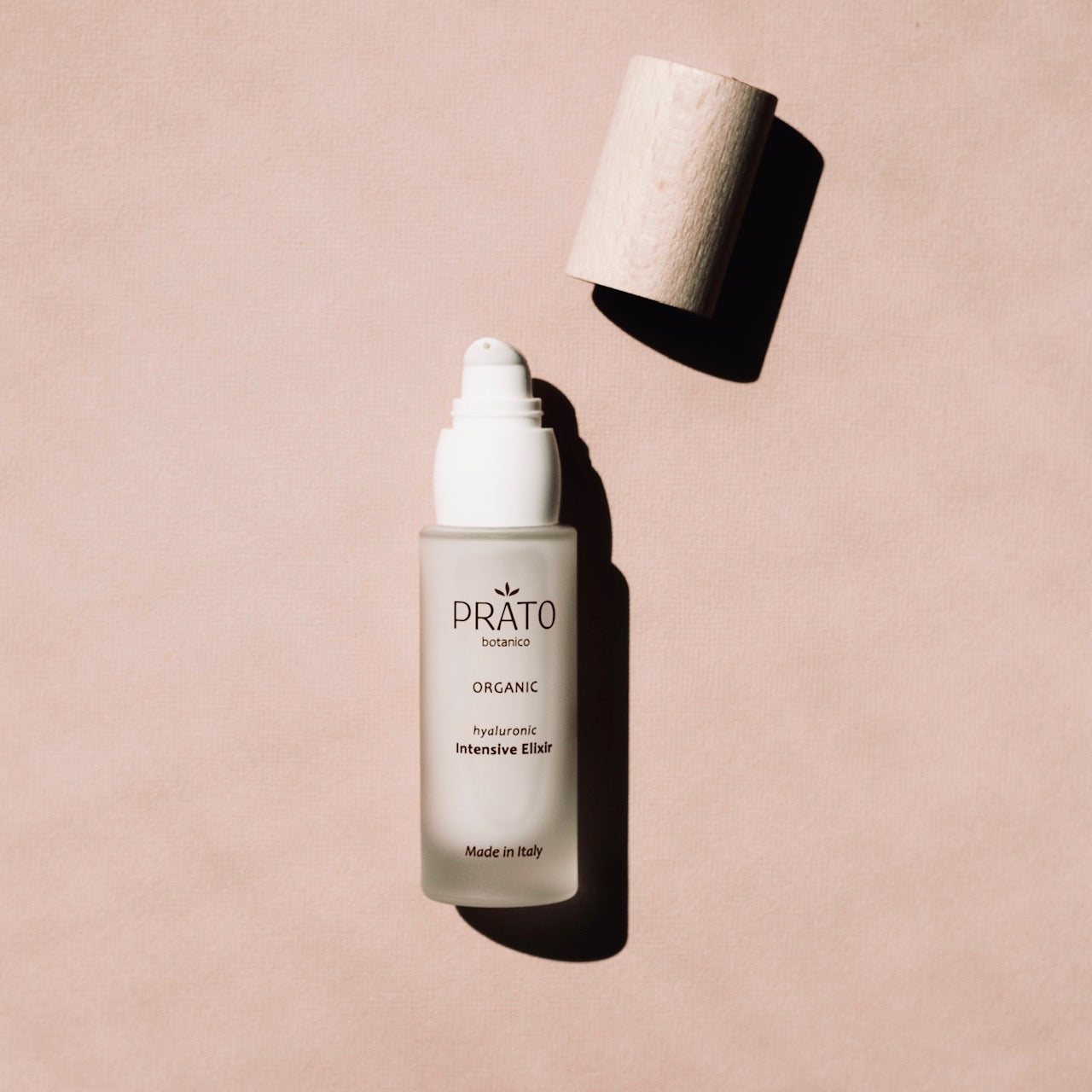 Organic hyaluronic acid Prato Botanico Intensive Elixir with sustainable beechwood lid on pink background