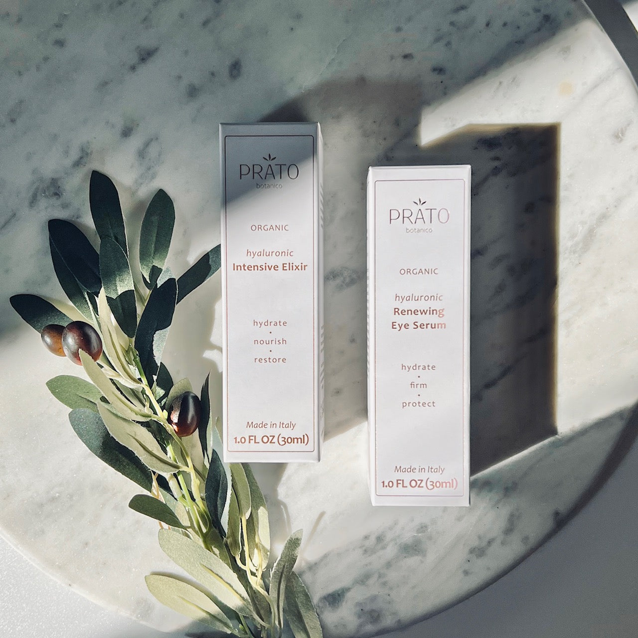 Organic Hyaluronic acid Prato Botanico Skin Illuminating Set upright on marble with olive leaf