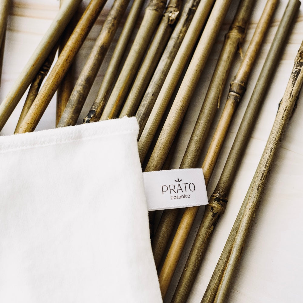 Prato Botanico Bamboo Cleansing Cloth laying on bamboo shoots on a table